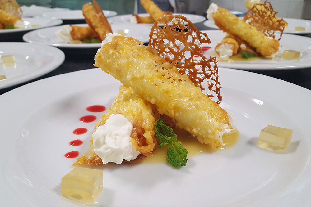 Canutillos de naranja rellenos de mousse de yogur, puré de manzana, gelatina de miel y crujiente de almendras